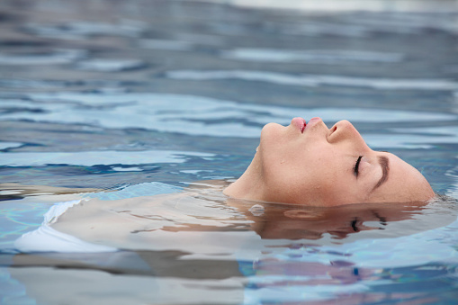 Woman floating and relaxing in tropical ocean water