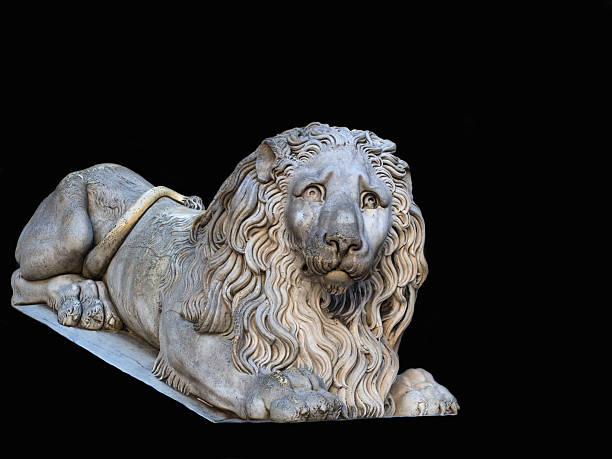 istock Big Lion old marble Statue isolated on black background 512437536