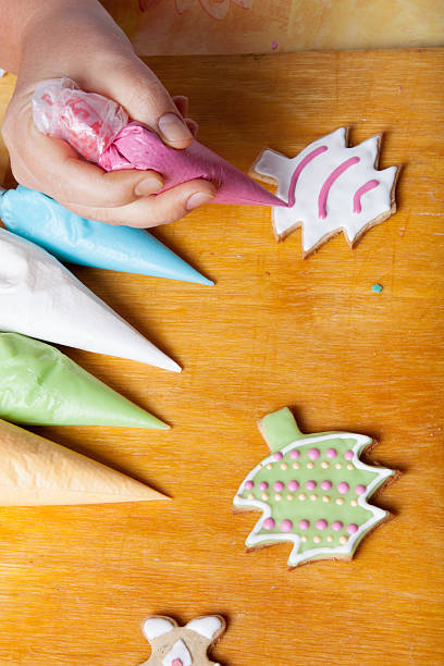 istock Woman's hands in process of drawing on gingerbread cook 512438976