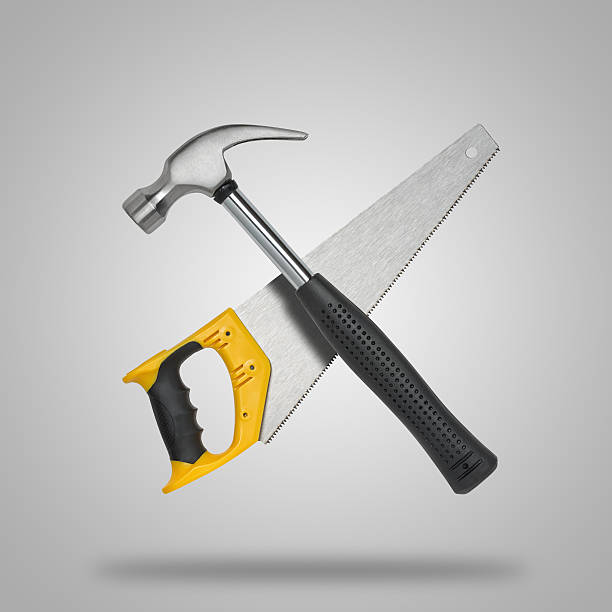 istock Crossed saw and hammer on gray background like icon 512439178