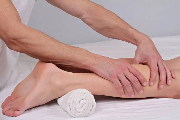 Woman enjoying leg massage.Therapist applying pressure on female leg.