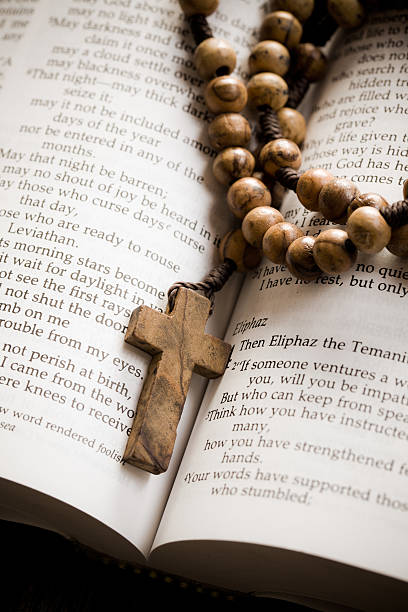 istock wooden rosary on the open Bible 512449505