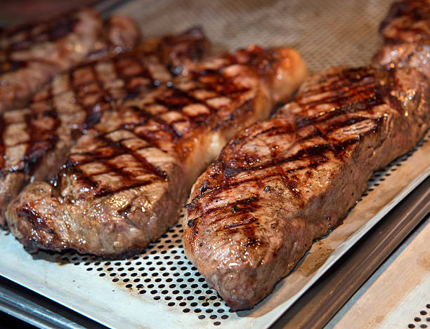 beef steak cooking on an open flame grill