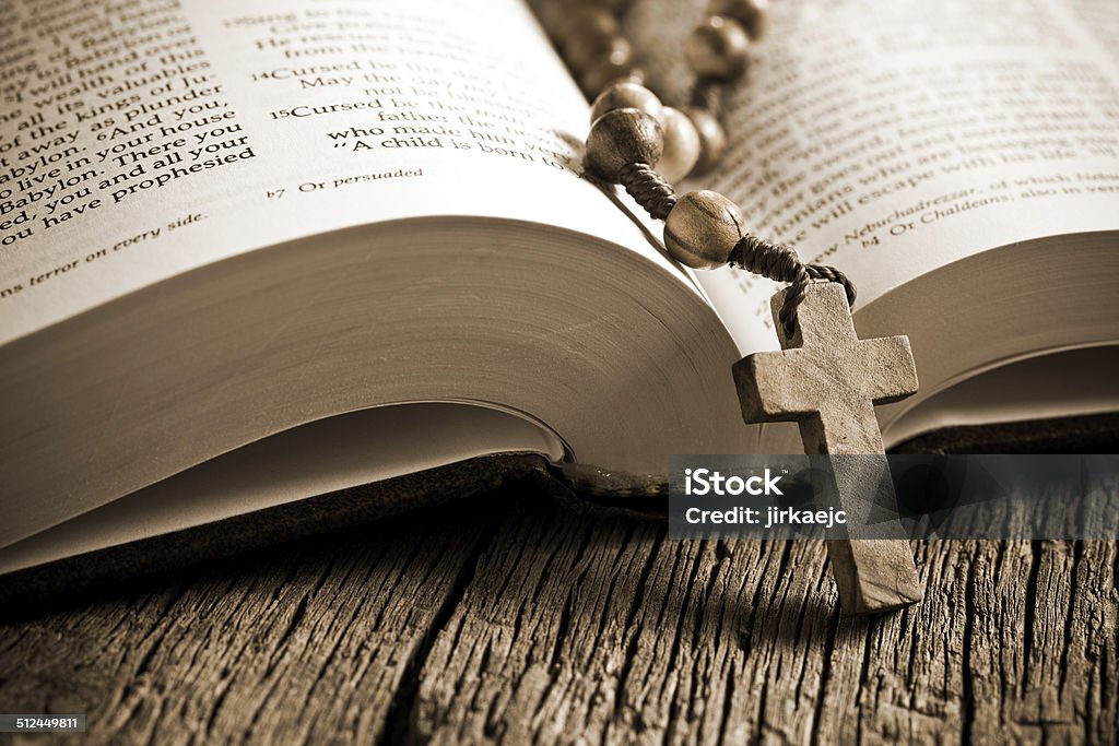 wooden rosary on the open Bible the wooden rosary on the open Bible Bible Stock Photo