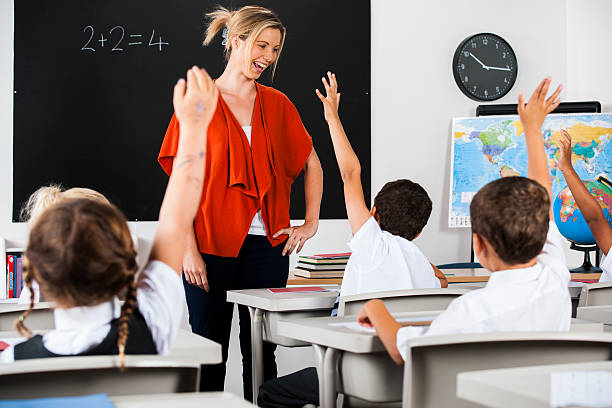 istock Class Of Enthusiatic Primary School Children With Their Hands Up 512452333
