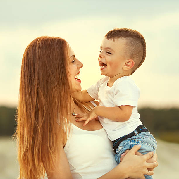 heureuse mère et son fils jouent dans les montagnes - single mother one parent child kissing photos et images de collection