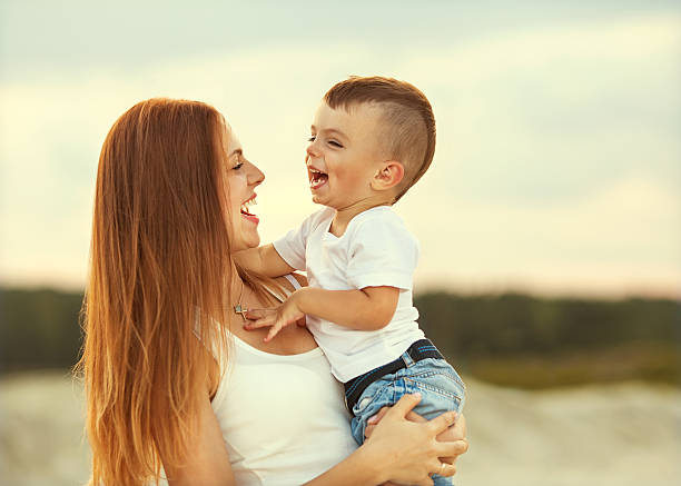 heureuse mère et son fils jouent dans les montagnes - single mother one parent child kissing photos et images de collection