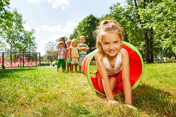 istock Nice girl crawling thought the tube in park 512453967