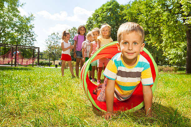 istock Playing crawling though tube on the lawn 512453969