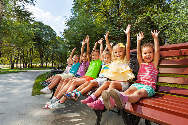 Adorable children sits on a park bench