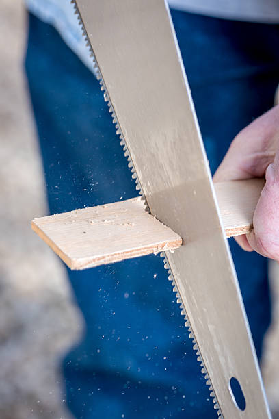 istock Sawing wood with a saw closeup 512454322