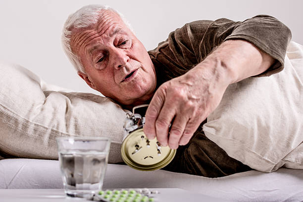 istock Senior man switching off the alarm clock 512456122