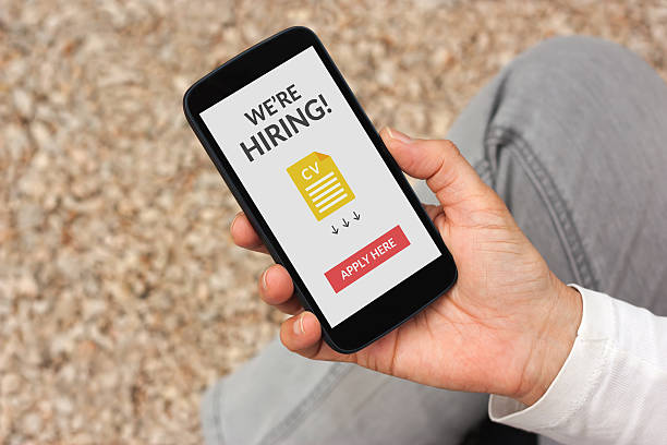 istock Hand holding smartphone with we are hiring concept on screen 512458080