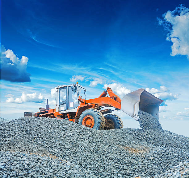 istock wheel loader excavator working with  gravel on big pile 512458666