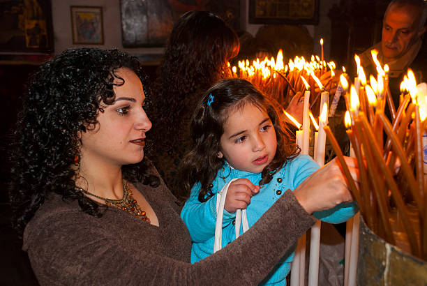 Cute girl is praying with candle in her hand