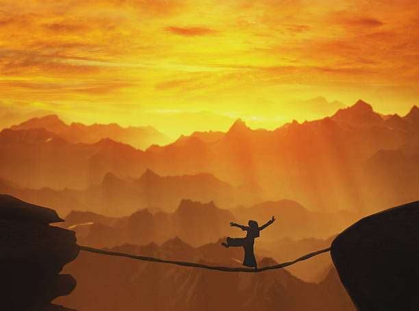 istock Highline walker silhouette in mountains at sunset 512460178