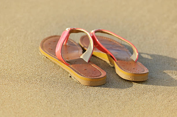 istock Summer vacation concept. Sandals on a sandy ocean beach 512472978