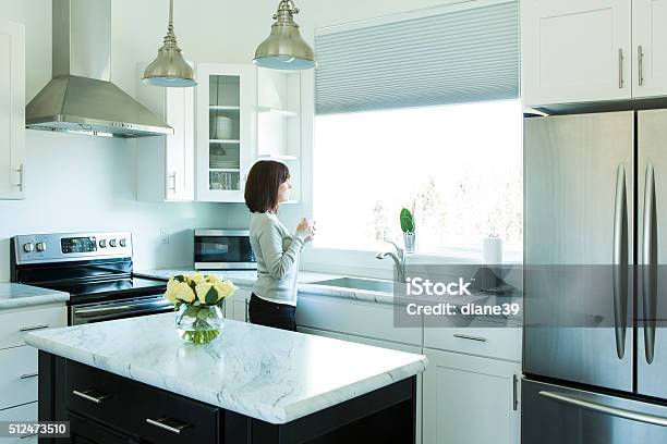 Woman Drinking Coffee In A Modern Kitchen Stock Photo - Download Image Now - Kitchen, People, Window