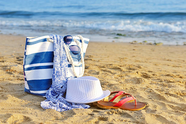 istock Hat, bag, sun glasses and flip flops on sandy beach 512473768