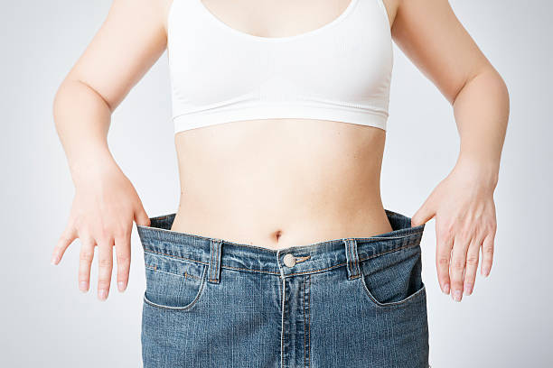 mulher jovem em jeans de tamanho grande - slenderize imagens e fotografias de stock