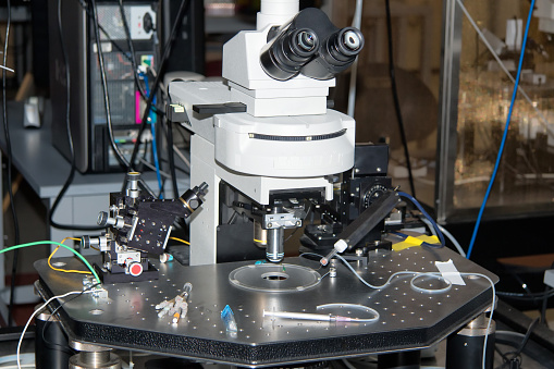 Fancy scientific instruments surround a microscope in a research laboratory