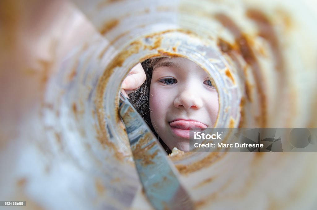 The end of the peanut butter jar The face of a little gorl getting the last trace of peanut butter with a knife in the jar and sticking tongue out, seen from the bottom of the jar Peanut Butter Stock Photo