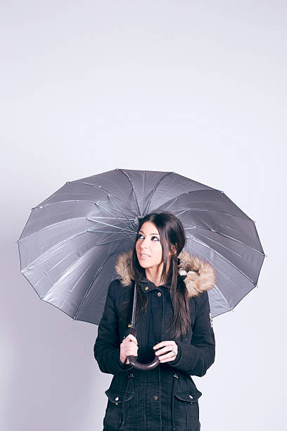 istock Woman holding an umbrella, over gray background 512489050