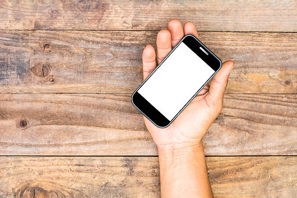 istock Smartphone in a male's hands on old wooden background 512489068