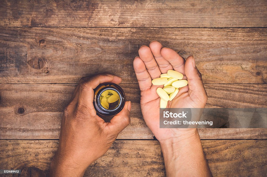 bottle pouring pills on a male's hand Pill Stock Photo