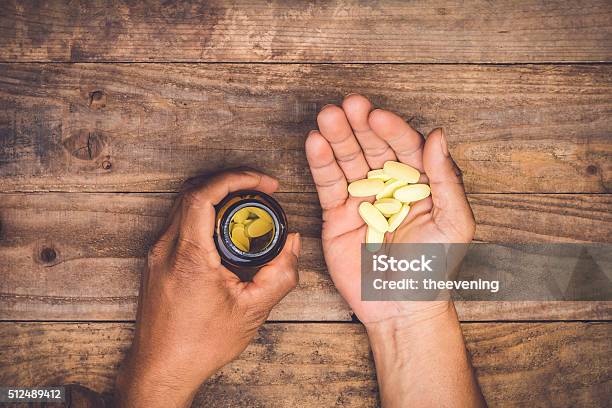 Bottle Pouring Pills On A Males Hand Stock Photo - Download Image Now - Pill, Vitamin, Men