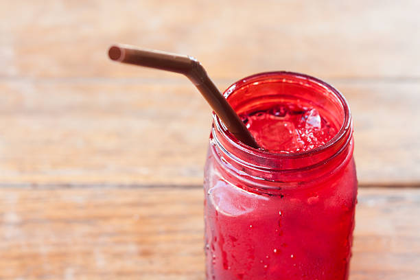 istock Iced drink in red glass on wooden table 512490480