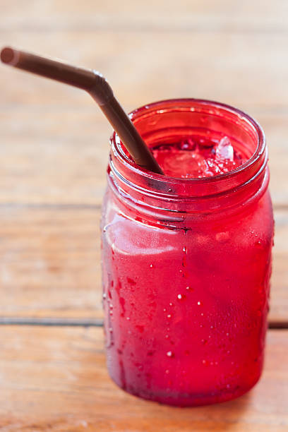 istock Iced drink in red glass on wooden table 512490528