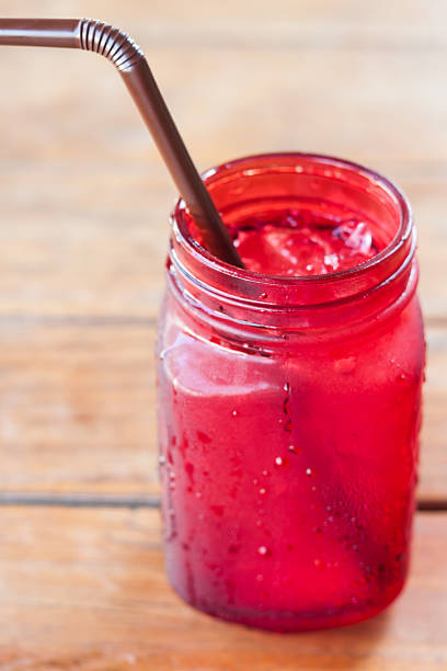 istock Iced drink in red glass on wooden table 512490650