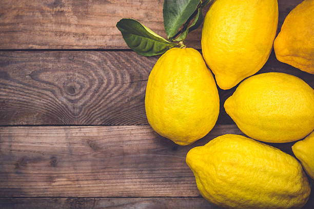 istock Fresh yellow lemon on old wooden table 512490754