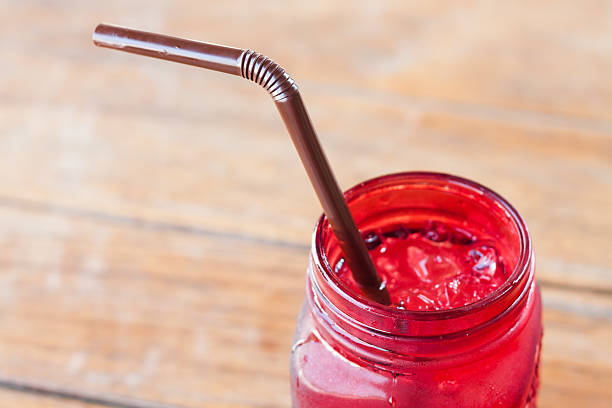 istock Iced drink in red glass on wooden table 512490760