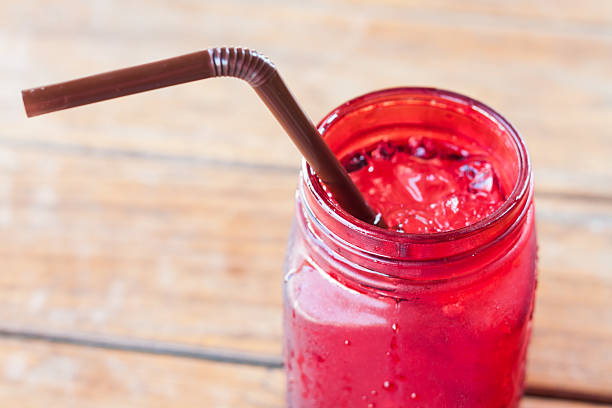 istock Iced drink in red glass on wooden table 512490862
