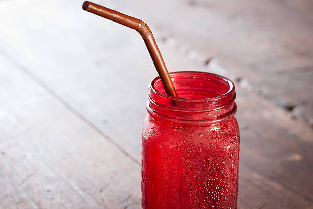 istock Iced drink in red glass on wooden table 512491232