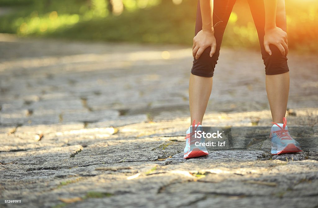 tired woman runner  have a rest after running hard tired female runner  taking a rest after running hard in countryside road.  sweaty athlete  after marathon training  in country road. Adult Stock Photo