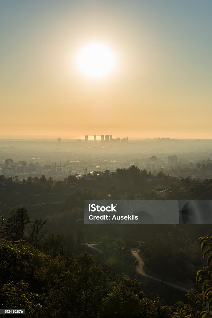 Griffith Park Trails and Century City at Sunset, sunlight and smog View from the Griffith Observatory at the trails of Griffith Park and the buildings of Century City in the distance. Los Angeles, California. Architecture Stock Photo