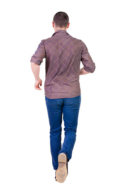 istock Back view of running man in brown shirt. 512493409
