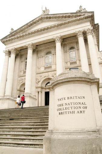 London, UK - July 6, 2014:  Two visitors walking up the grand steps at the front of Tate Britain art gallery.  The Gallery, overlooking the River Thames at Pimlico, houses works by British artists.