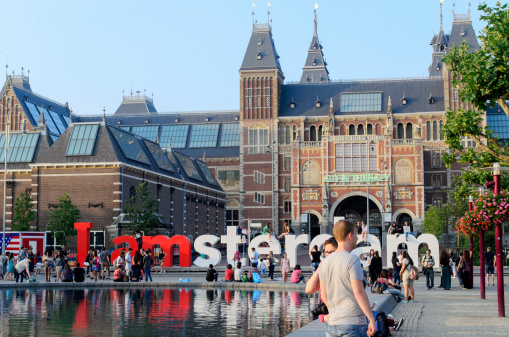 Amsterdam, Netherlands - July 26, 2014: The Rijksmuseum area with with the walking and sitting people. From the front, visible big letters \
