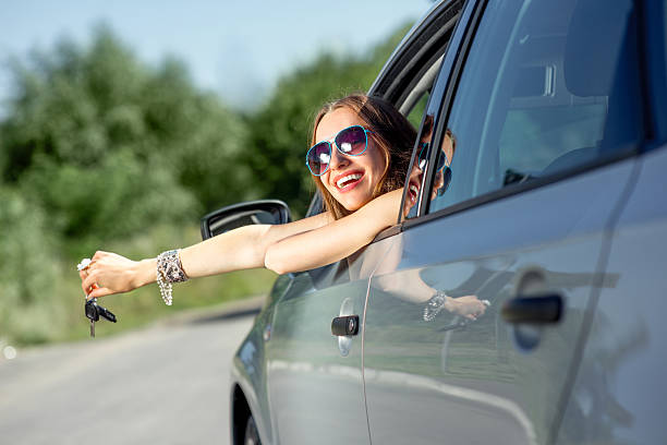 istock Car driver woman happy showing keys out window 512494601