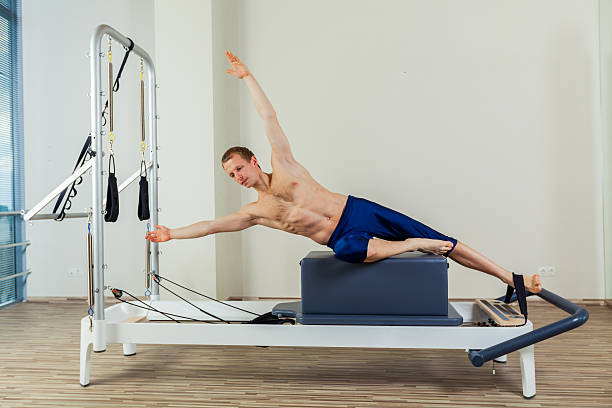 istock Pilates reformer workout exercises man at gym indoor 512494654