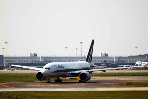Ferno, Italy - September 14, 2014: Alitalia passenger airplane ready to depart from runway of the Malpensa International Airport. Italy.