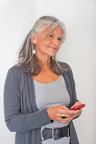 istock Beautiful middle aged woman smartphone white background thinking 512497147