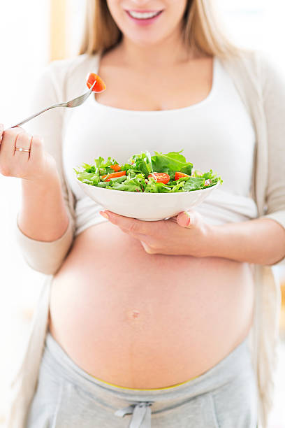 istock Pregnant woman eating salad 512498525