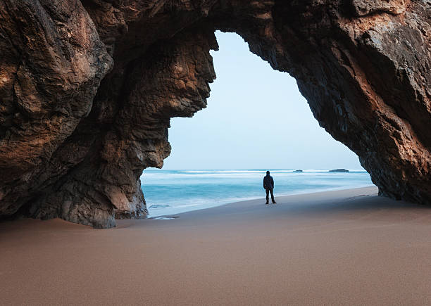 istock Lonely man under the rocky arch 512506528