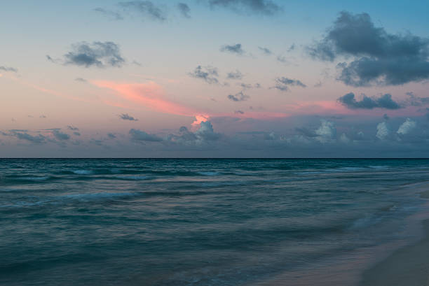 Colorful sky with rose cluds over serenity of evening Atlantic ocean