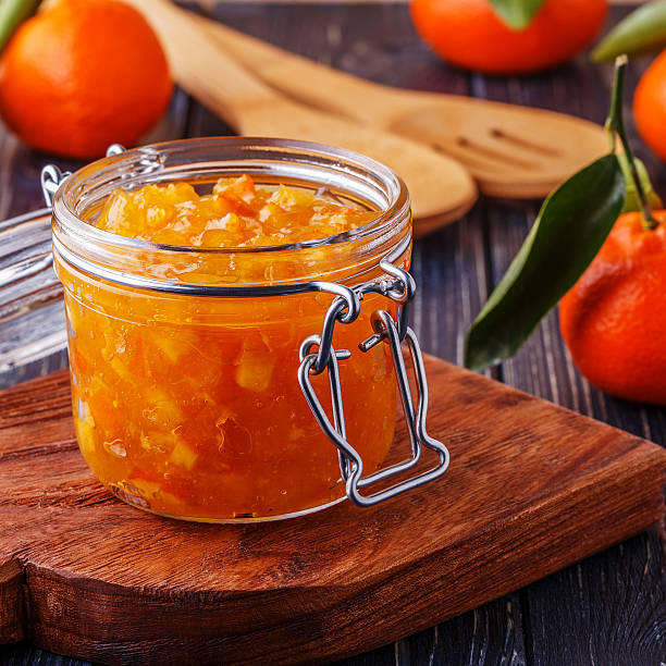 istock Orange (tangerine) jam in a glass jar on the table. 512510490